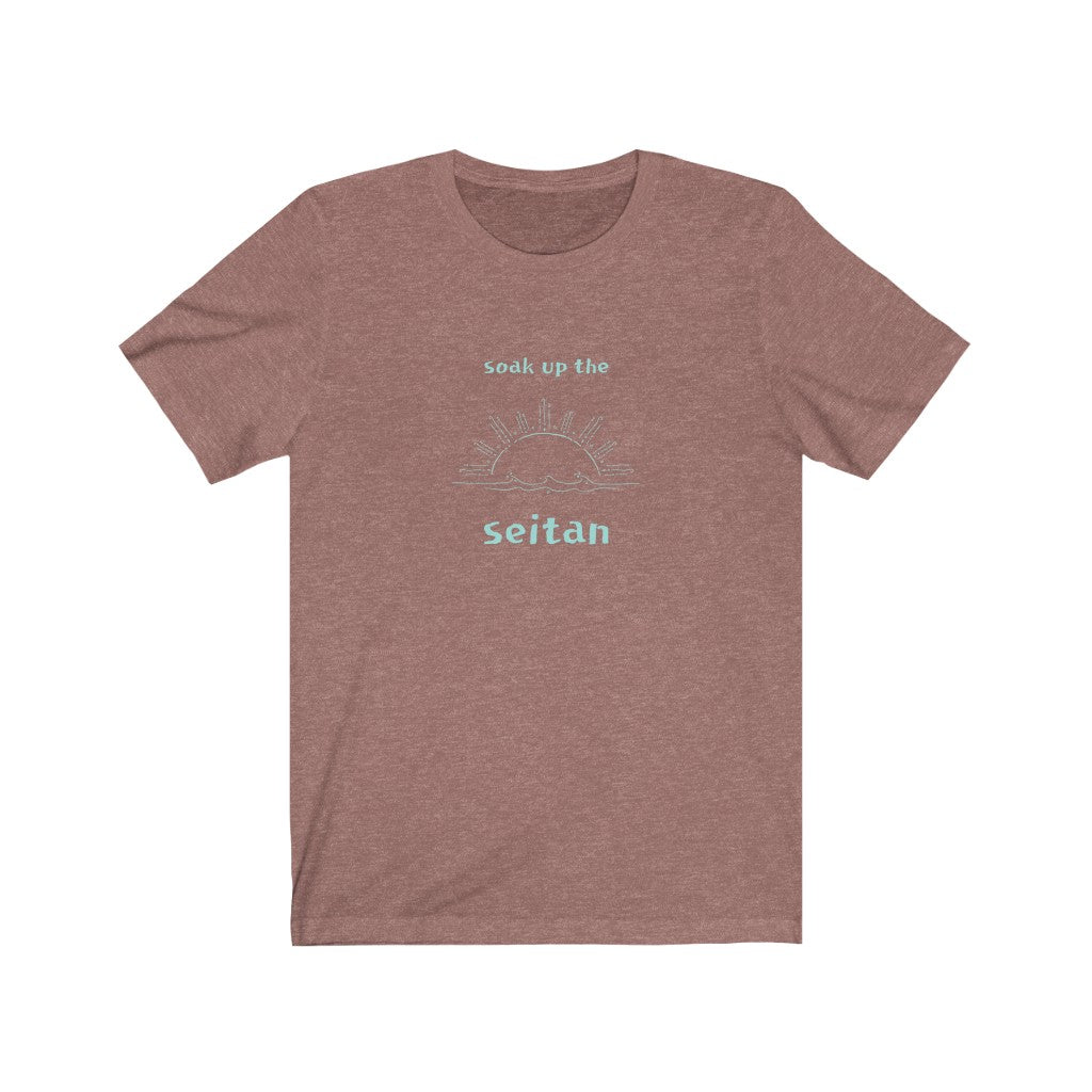 heather mauve vegan t shirt with a teal design saying soak up the seitan