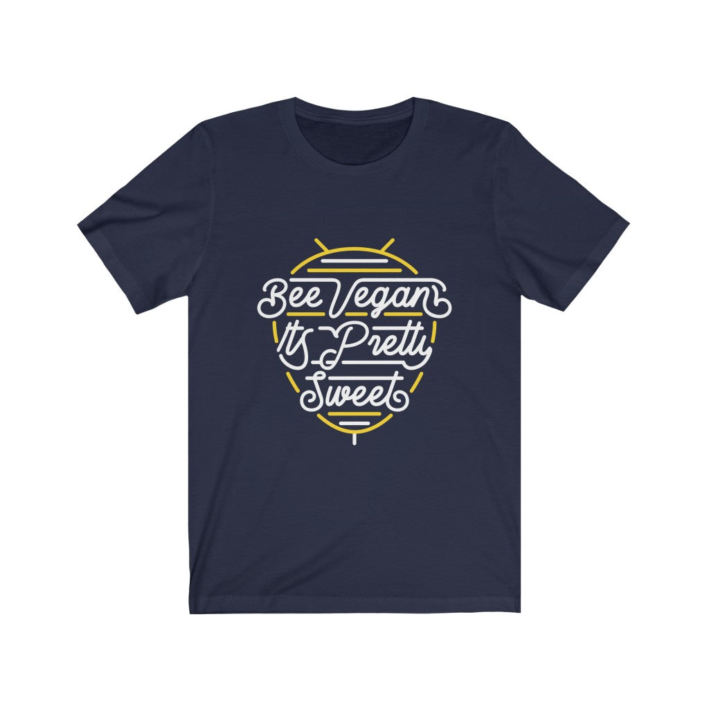 white lettering and yellow bee neon sign graphic design on navy colored premium cotton t shirt pictured flat with words bee vegan its pretty sweet, vegan t shirts from ethical clothing brands