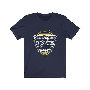 white lettering and yellow bee neon sign graphic design on navy colored premium cotton t shirt pictured flat with words bee vegan its pretty sweet, vegan t shirts from ethical clothing brands