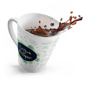 Latte mug saying eat plants and prosper with a green vegetable pattern, tipping over with coffee spilling out