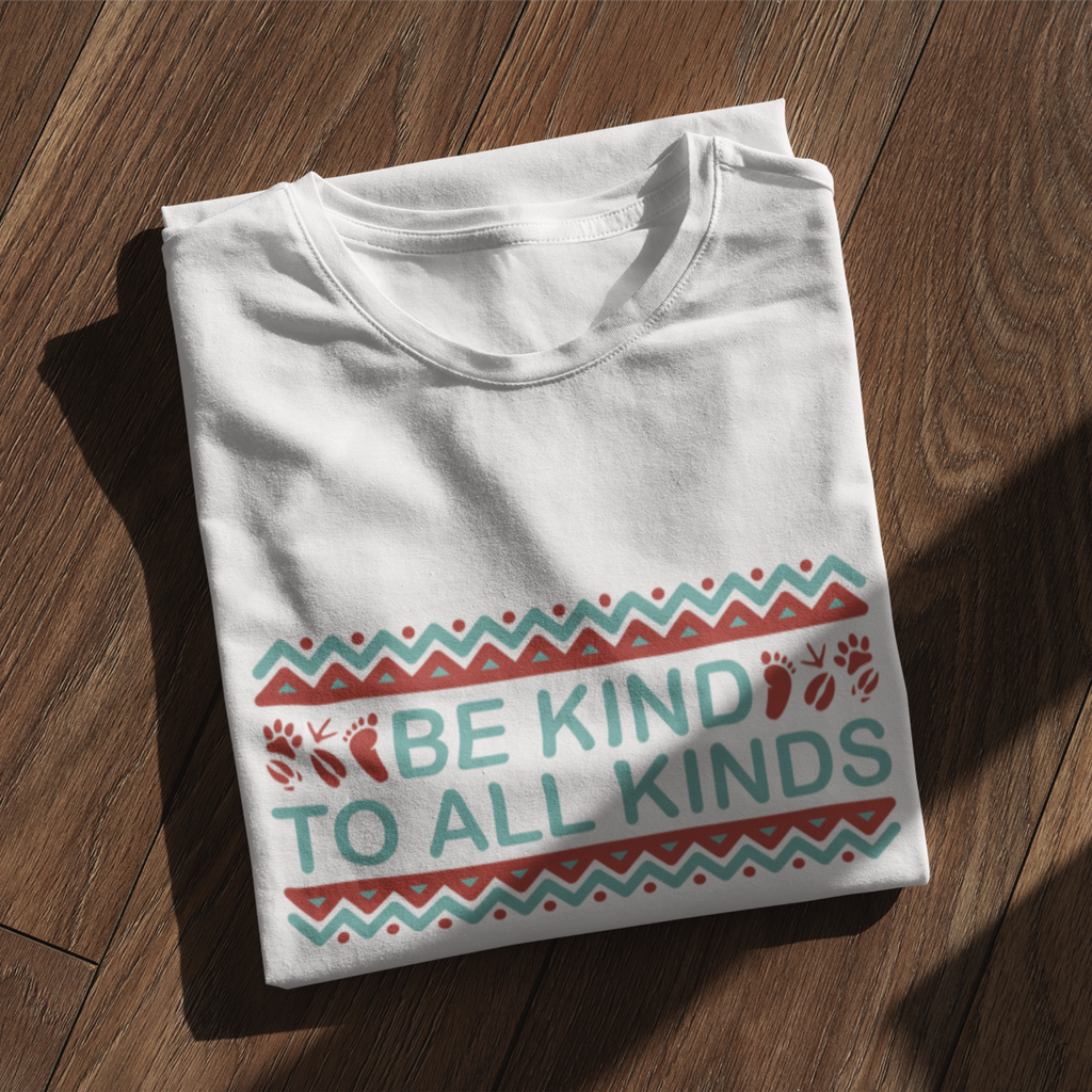 folded white vegan shirt with teal and burgundy design saying "be kind to all kinds" with a frame featuring zig zags and dots in boho style, with human and animal foot prints next to "be kind"