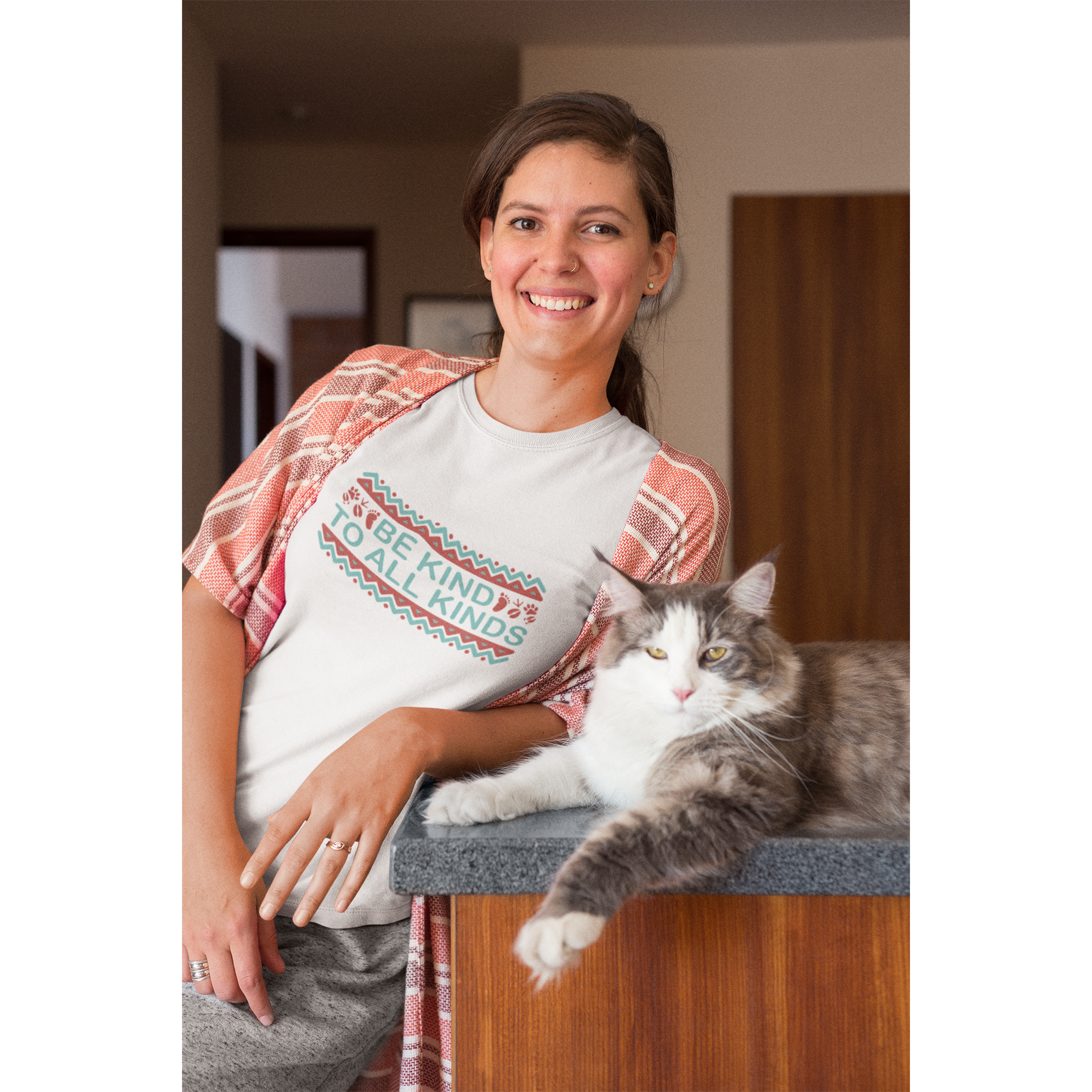 woman leaning with cat wearing "be kind to all kinds" boho style white vegan t shirt made for boho tops