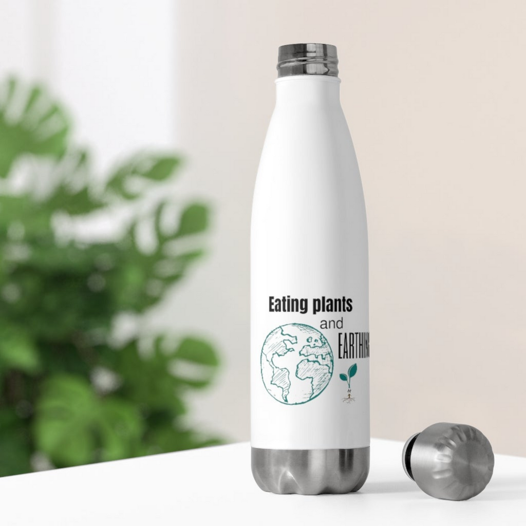 eco friendly water bottles in white with black lettering saying eating plants and earthing and a green earth and plant