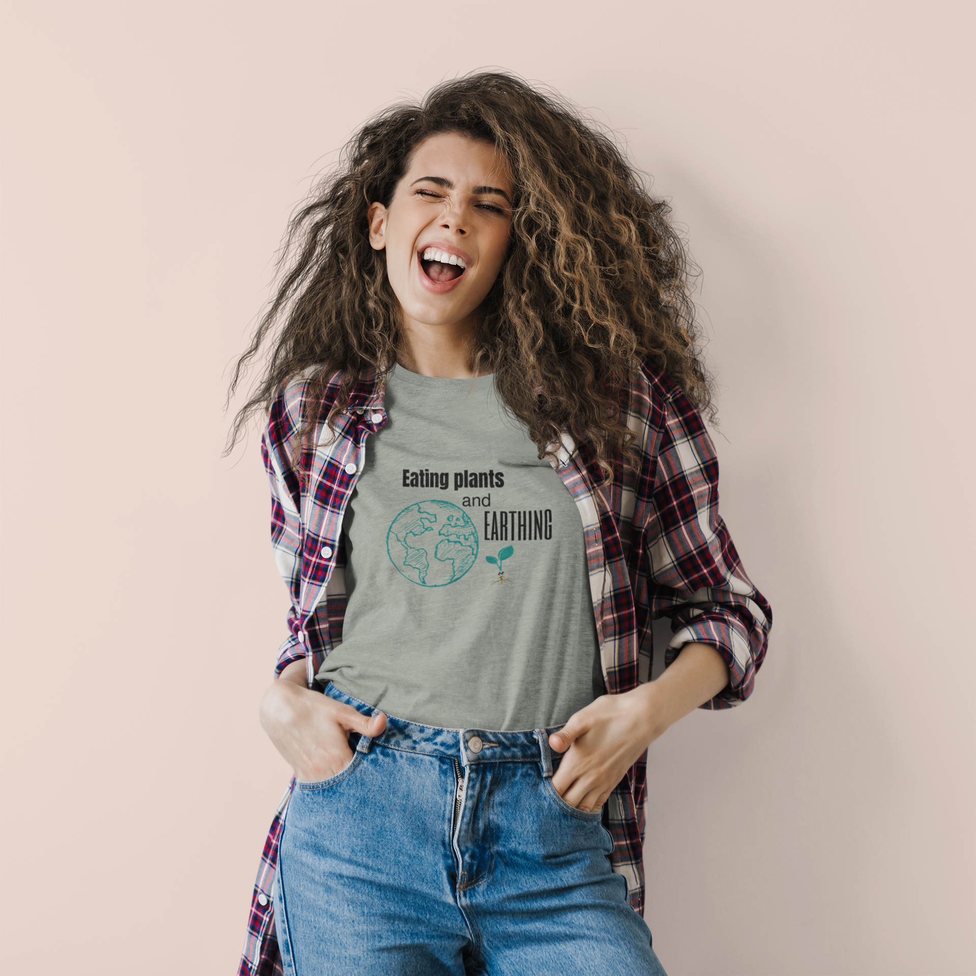 young happy woman wearing an eating plants and earthing vegan t shirt design on athletic heather color premium cotton t shirt for those who eat plants and enjoy their earthing mat