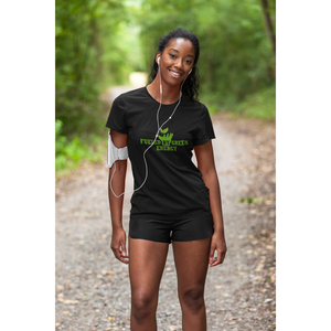 young woman jogger on a trail with trees wearing a green "fueled by green energy" design on a black colored vegan shirt and vegan workout clothes