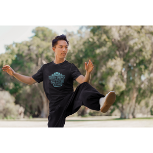 man doing karate in park wearing black vegan shirt saying "green energy is the future, go vegan", from ethical clothing brands and companies that donate to nonprofits
