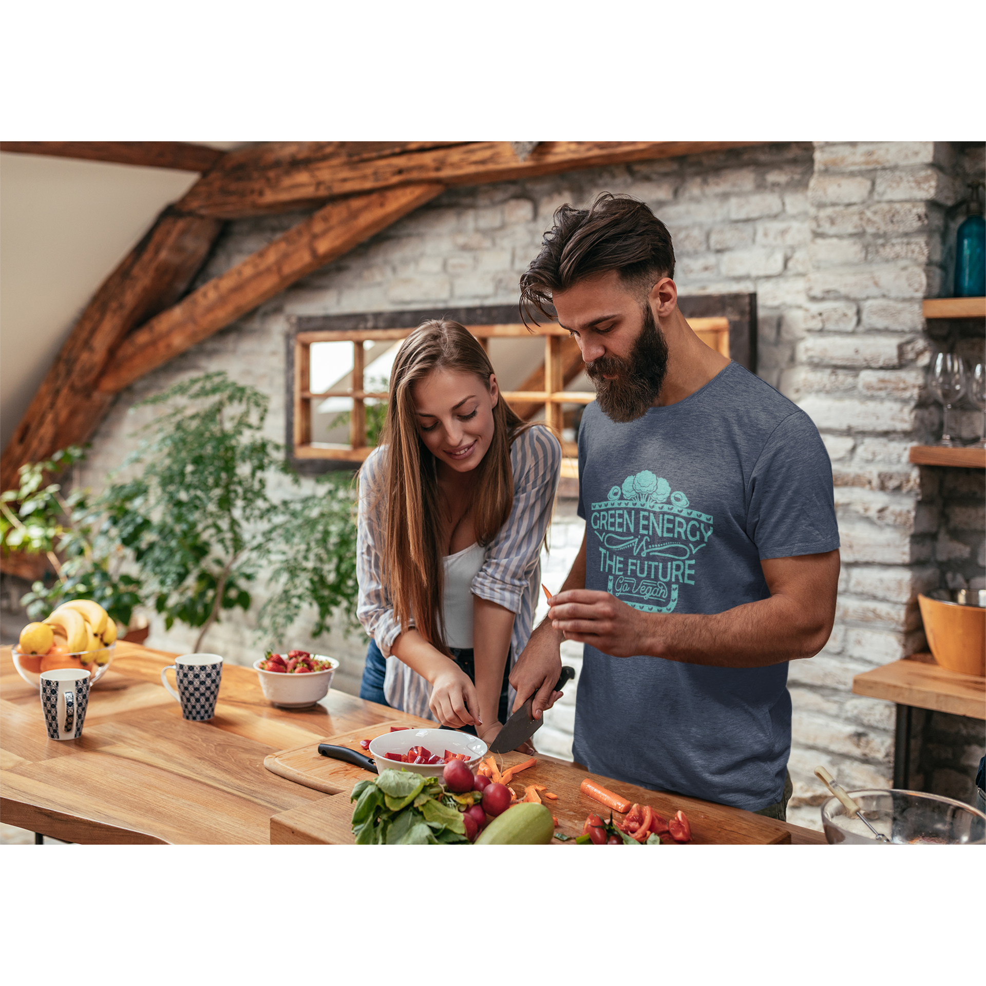 couple cooking vegetables while man wears "green energy is the future, go vegan" vegan shirt with teal lettering and heather navy premium cotton material