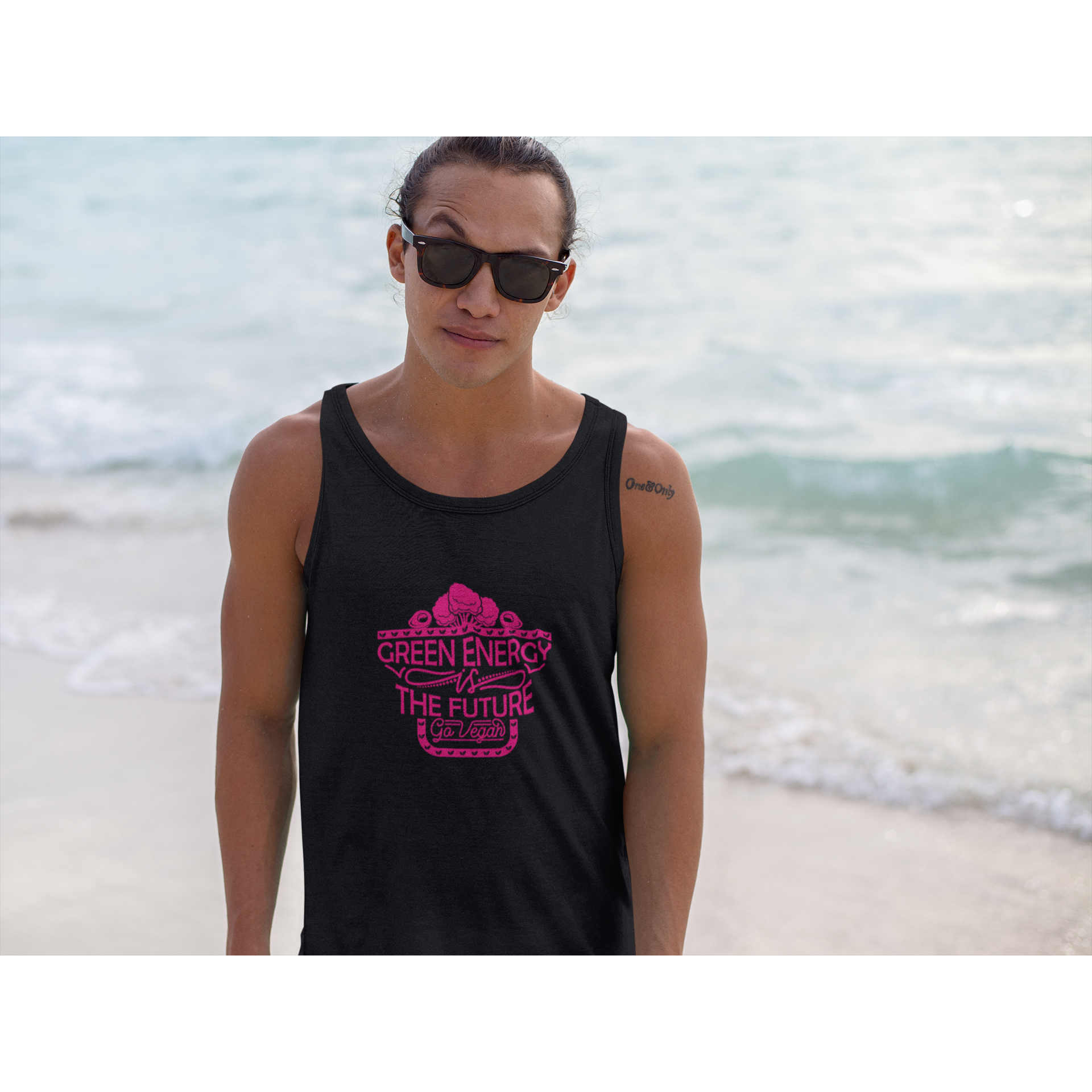 Man wearing black unisex vegan tank top on the beach with pink design saying green energy is the future go vegan
