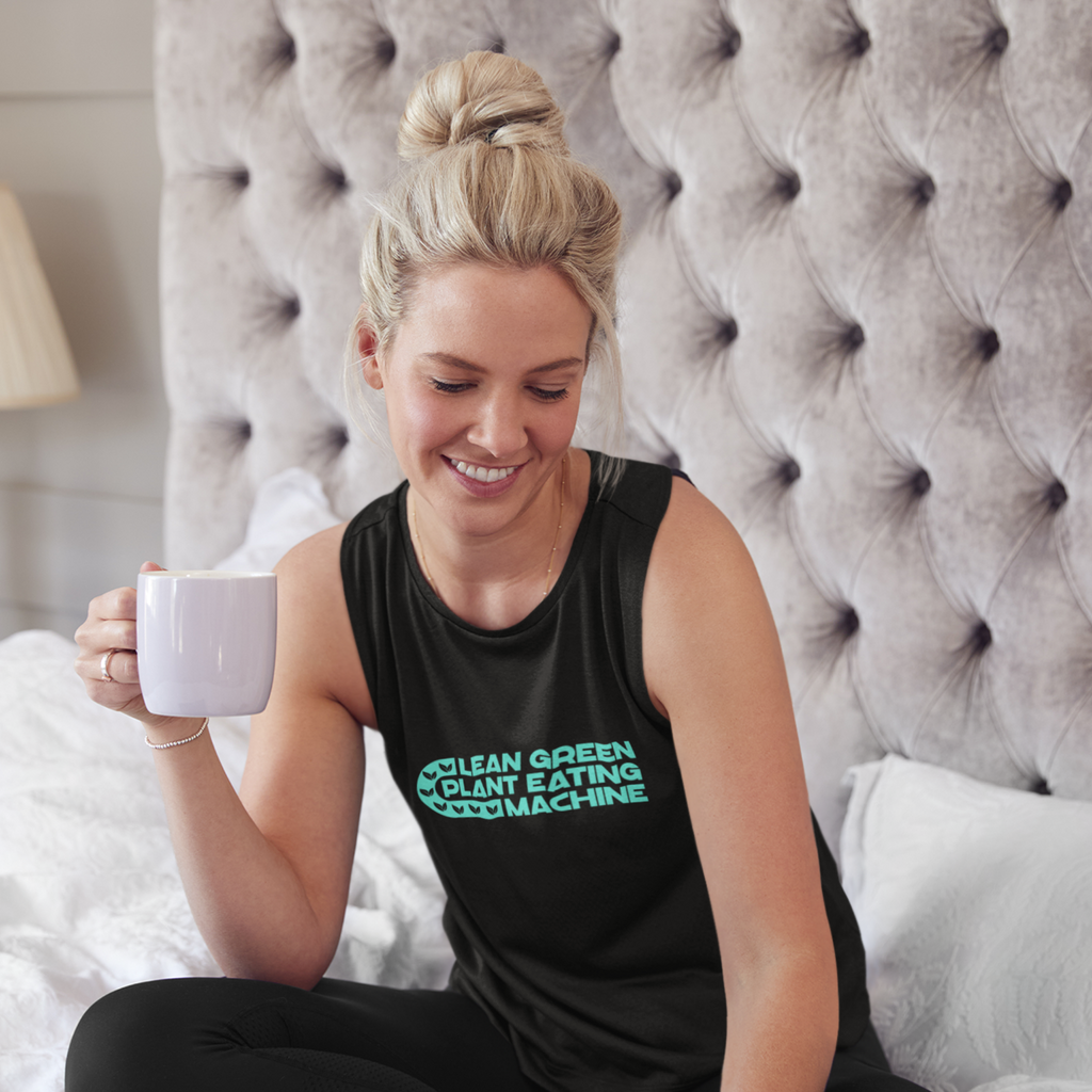 woman drinking coffee with black flowy tank tops with green words saying lean green plant eating machine