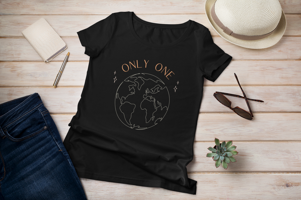 Ladies organic scoop neck vegan t-shirt in black saying only one earth and laid flat on wood