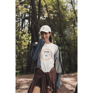woman with a hat in the woods wearing a white vegan t shirt with black lettering and tan and peach fern circle, saying plants have protein too without the cholesterol