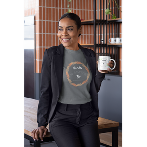 woman in professional black suit with a coffee mug, wearing an asphalt grey colored vegan t shirt with white lettering and tan and peach fern circle, saying plants have protein too without the cholesterol