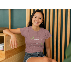 Asian woman in a booth wearing a heather mauve colored vegan shirt with white lettering and design, and green leaves, saying plants have protein too without the cholesterol