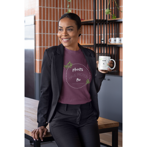 vegan t shirt worn by a woman in a suit, white lettering and green leaves on a maroon premium tee that says plants have protein too without the cholesterol
