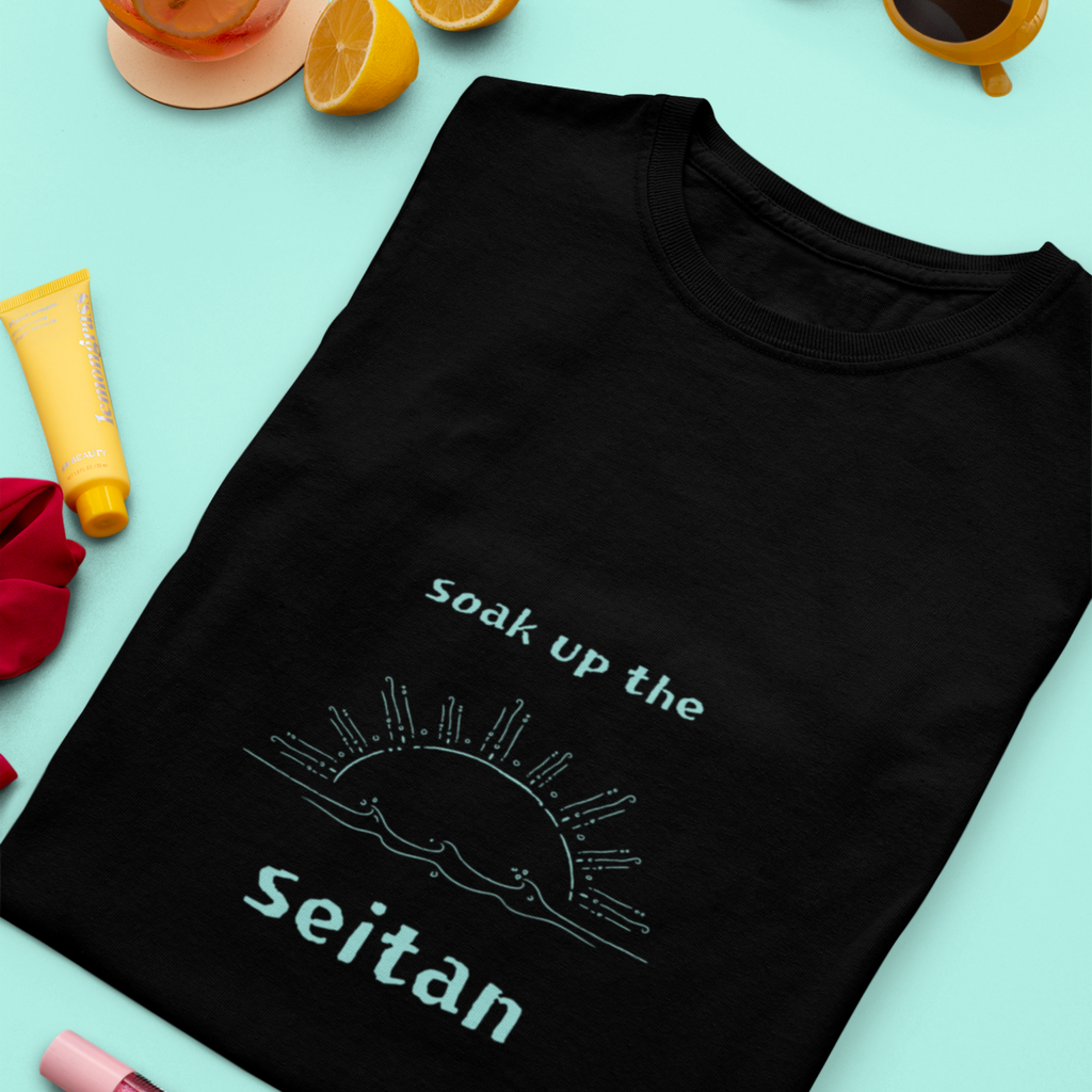 Soak up the seitan teal design on a black folded premium vegan t shirt