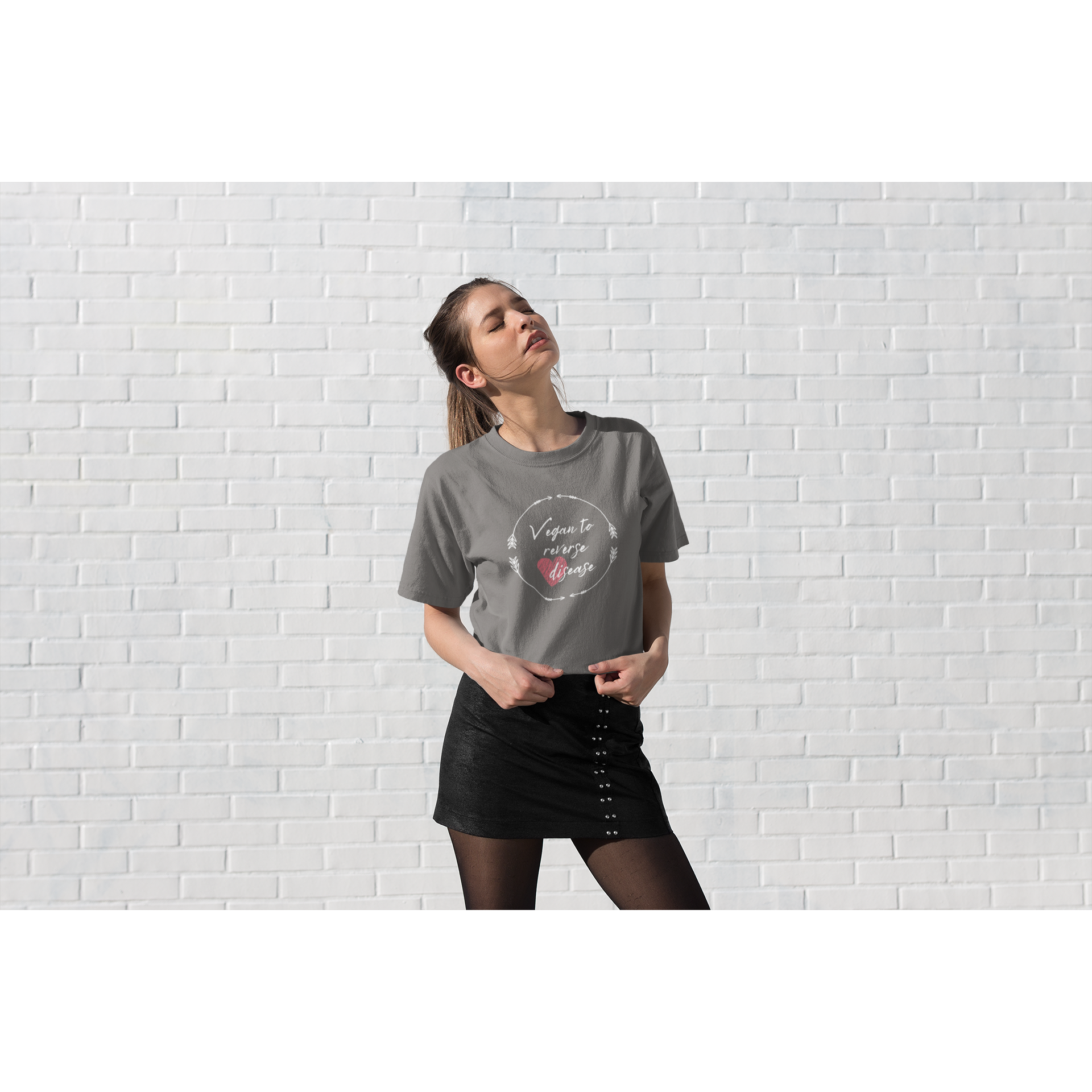 woman outside in sun  wearing a vegan t shirt saying vegan to reverse heart disease