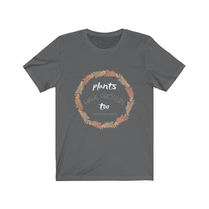 white tan and peach design on asphalt grey vegan shirt on a plain white background, saying plants have protein too without the cholesterol, from ethical clothing brands and companies that donate to nonprofits