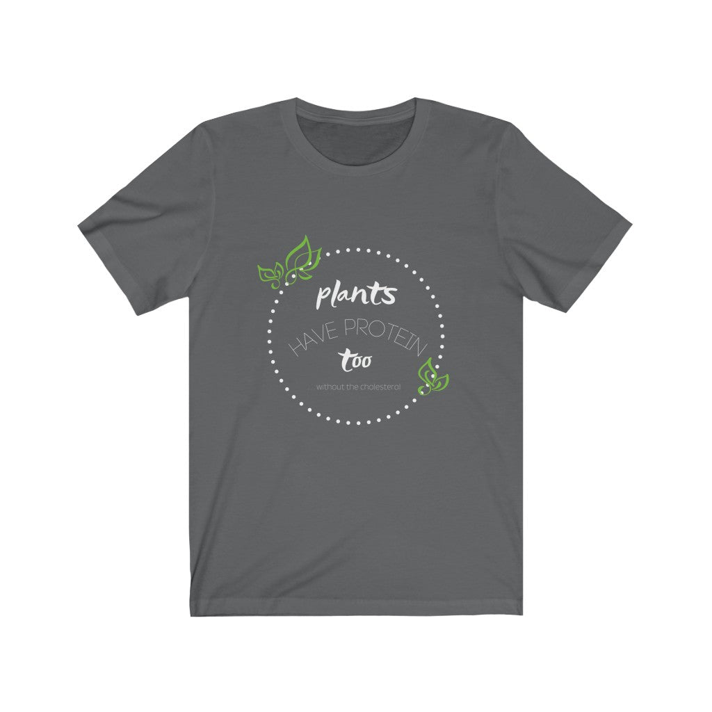 vegan t shirts design on asphalt vegan shirt, with design in white and green saying plants have protein too without the cholesterol, laying flat on white background, from ethical clothing brands and companies that donate to nonprofits