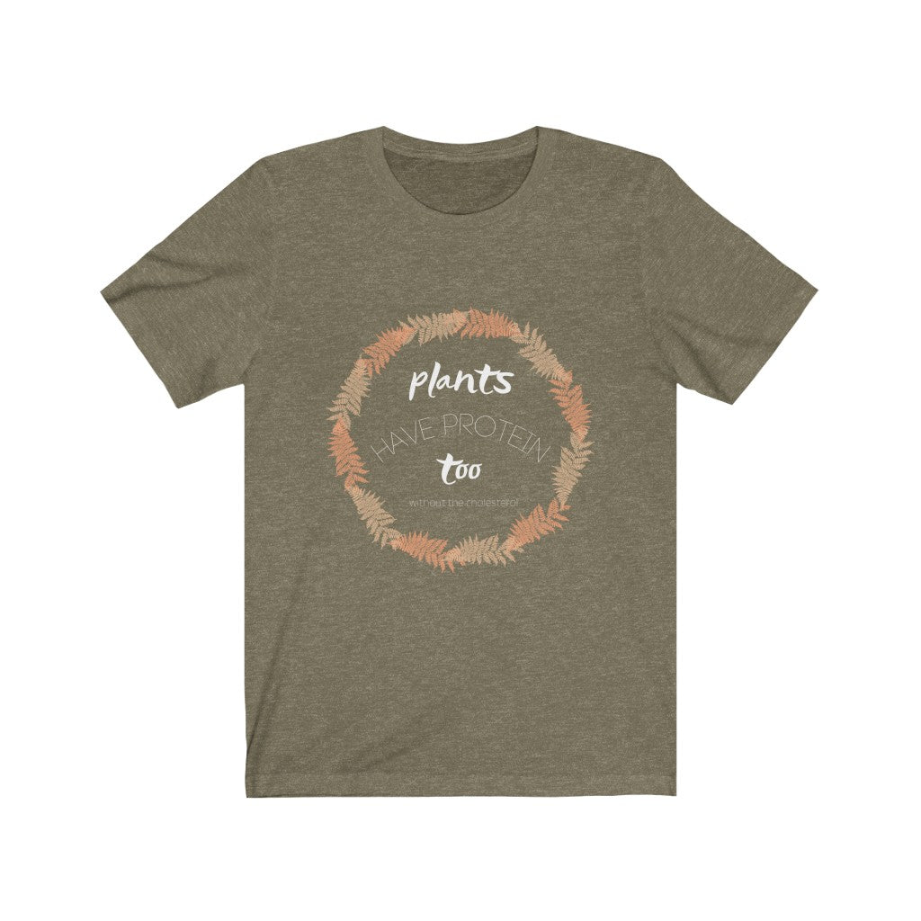 vegan shirts design in white lettering with a peach and tan circle on a heather olive vegan t shirt on a white backdrop, saying plants have protein too without the cholesterol, from ethical clothing brands and companies that donate to nonprofits