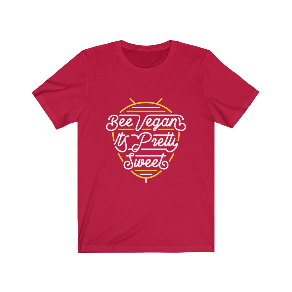 white lettering and yellow bee neon sign graphic design on red colored premium cotton vegan t shirt pictured flat with words bee vegan its pretty sweet, vegan shirts from ethical clothing brands