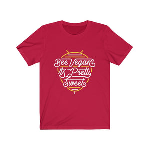 white lettering and yellow bee neon sign graphic design on red colored premium cotton vegan t shirt pictured flat with words bee vegan its pretty sweet, vegan shirts from ethical clothing brands