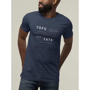 tofu shirt design with a tofu eats word salad design on a navy premium vegan t shirt worn by a smiling man