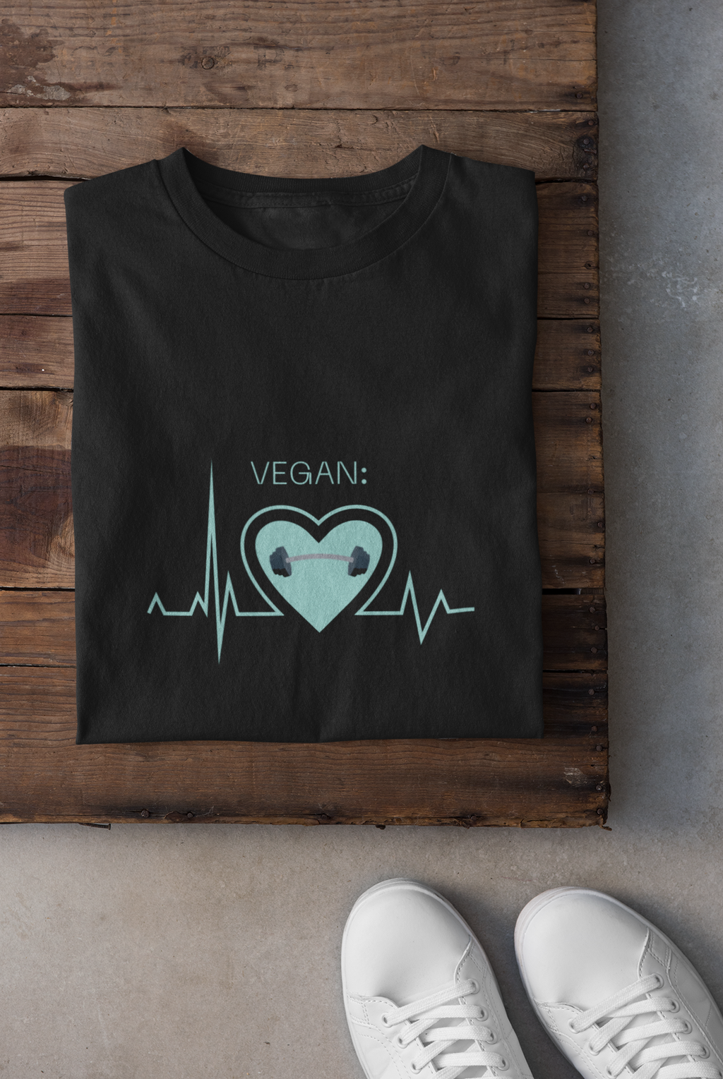 vegan heartbeat t-shirt with a dumbbell, folded on a piece of wood