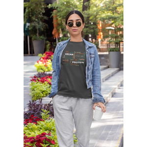 vegan protein word salad in fall colors on a dark grey vegan t shirt worn by a woman walking outside