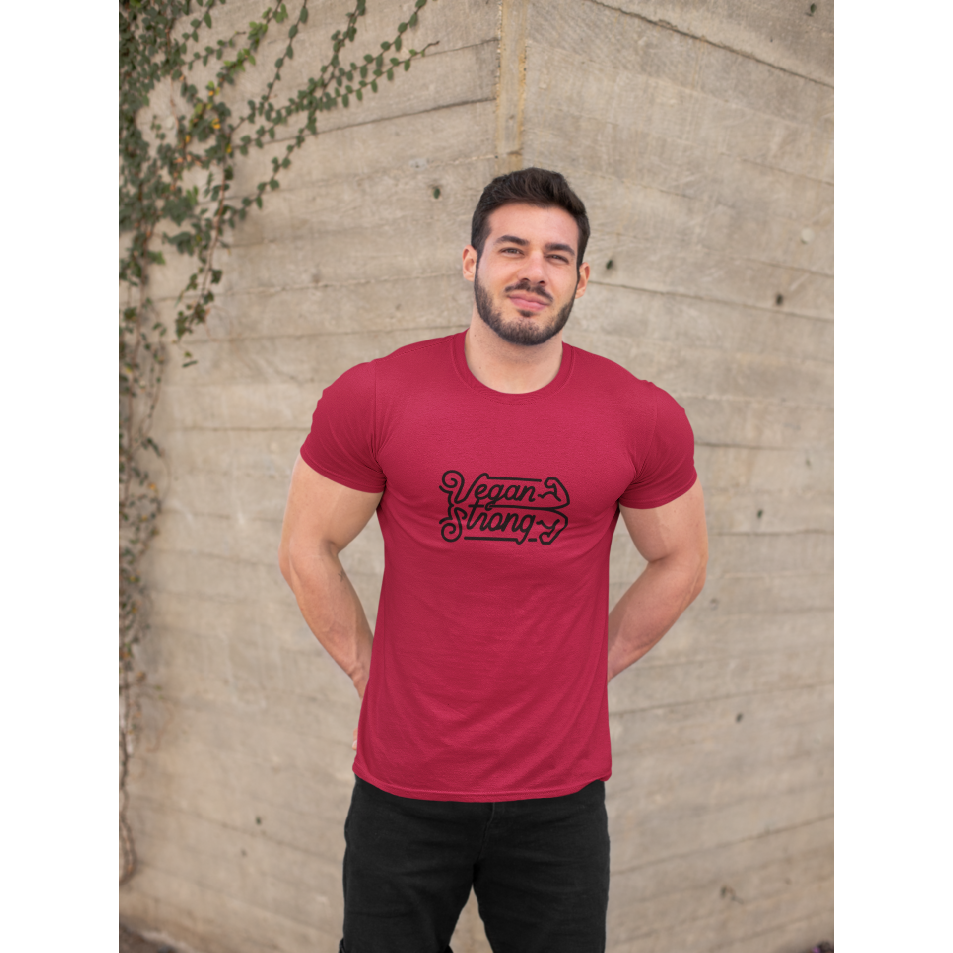 red vegan t shirt saying vegan strong worn by a muscular man standing outside